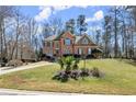 Stately brick home on a sprawling green lawn, framed by mature trees and blue skies at 1510 Habersham Pl, Cumming, GA 30041