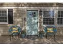 Inviting front porch with light blue door, stylish seating, potted plants, and decorative accents at 1000 Bozeman Dr, Atlanta, GA 30341