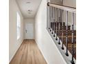 Inviting hallway with hardwood flooring and a staircase featuring wrought iron balusters at 5113 Rapahoe Trl, Atlanta, GA 30339