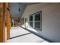 Covered front porch with wooden beams, concrete flooring, and exterior view of the home's entrance at 526 Myrtle St, Villa Rica, GA 30180