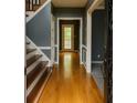 Inviting foyer with hardwood floors, staircase, and doorway leading to the rear patio at 2431 Weatherstone Se Cir, Conyers, GA 30094