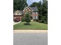 Beautiful two-story brick home with manicured lawn and mature trees providing privacy at 2431 Weatherstone Se Cir, Conyers, GA 30094