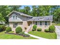 Charming home featuring a brick facade, complemented by lush landscaping and mature trees at 2657 Langland Ne Ct, Atlanta, GA 30345
