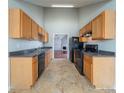 Functional galley kitchen featuring wood cabinets, granite counters, and black appliances at 4932 Wilkins Station Dr, Decatur, GA 30035