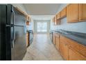 Functional galley kitchen featuring wood cabinets, granite counters, and black appliances at 4932 Wilkins Station Dr, Decatur, GA 30035