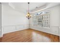 Spacious dining room boasting hardwood floors, wainscoting, and a large window for natural light at 911 Telfair Close, Sandy Springs, GA 30350