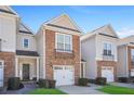 Well-maintained townhome showcasing stone accents, a single-car garage, and a welcoming covered entryway at 2502 Capella Sw Cir, Atlanta, GA 30331