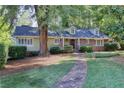 Inviting outdoor pool area with stone accents, lounge chairs, and mature trees at 415 S Woodland Sw Dr, Marietta, GA 30064