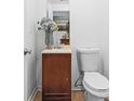 Small bathroom featuring a toilet, vanity, and decorative floral arrangement at 6945 Merrywood Dr, Fairburn, GA 30213