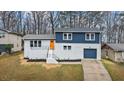 Charming two-story home featuring a white brick facade, blue accents, and a bright orange front door at 3565 Collier Drive Nw Rd, Atlanta, GA 30331