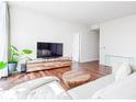 Modern living room with hardwood floors, a large TV, a contemporary media console, and a white sofa at 45 Ivan Allen Jr Nw Blvd # 1908, Atlanta, GA 30308