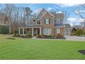 Attractive two-story home with a brick facade, columns, and a lush front yard at 1366 Kings Park Nw Dr, Kennesaw, GA 30152