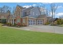 Exterior view showing three-car garage, well maintained lawn, and outdoor gazebo at 1366 Kings Park Nw Dr, Kennesaw, GA 30152