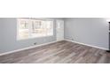 Bright living room with large window, light gray walls, and stylish modern gray and brown flooring at 1650 Seayes Sw Rd, Mableton, GA 30126
