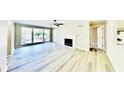 Bright living room with a fireplace, a ceiling fan, and large windows that provide plenty of natural light at 810 Berkeley Woods Dr, Duluth, GA 30096