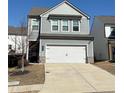 Charming two-story home featuring a gray siding, a two-car garage, and a well-maintained front lawn at 156 Auburn Crossing Dr, Auburn, GA 30011