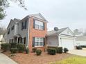 Two-story home with garage, featuring brick facade, vinyl siding, and tidy landscaping at 235 Windcroft Nw Ln, Acworth, GA 30101