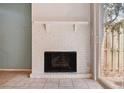 A close-up of a white brick fireplace and sliding glass doors leading to the backyard at 2551 Bradford Ne Sq, Atlanta, GA 30345