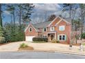 Brick home featuring a two-car garage, beautiful lawn, and mature trees at 775 Hales Trace Sw Way, Lilburn, GA 30047