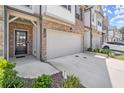 Beautiful brick townhome with a spacious driveway and attached garage, enhanced by manicured landscaping at 1409 Ben Park Way, Grayson, GA 30017