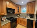 Bright kitchen featuring wood cabinetry, granite countertops, and a gas range at 5400 Roswell Rd # K1, Atlanta, GA 30342