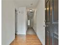 View of the hallway featuring hardwood floors and multiple doors leading to other rooms at 4607 Ravenwood Loop, Union City, GA 30291