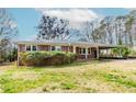 Traditional one-story brick home with a convenient carport and manicured green lawn in a residential area at 3951 Lindley Dr, Powder Springs, GA 30127