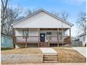 Inviting home featuring a raised porch, stairs, and a well-manicured front lawn at 907 Oakhill Sw Ave, Atlanta, GA 30310