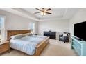 Spacious main bedroom with a tray ceiling, large windows, and a comfortable seating area at 5345 Coltman Dr, Cumming, GA 30028