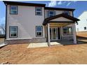 A view of the back of the house with a covered patio and sliding glass door entrance at 7685 Homer Dr, Cumming, GA 30028