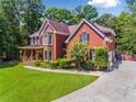 Spacious brick home featuring a lush green lawn, mature trees, and a side-entry garage at 475 Highland Gate Cir, Suwanee, GA 30024