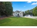 A beautifully landscaped front yard leads to a pristine white home, creating a welcoming and picturesque scene at 136 Huntcliff Trl, Ellenwood, GA 30294