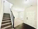 Inviting entryway with dark wood floors leading to a carpeted living area and staircase at 4417 Belcamp Rd, Fairburn, GA 30213