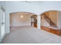 Open-concept living room with archways, hardwood floors, a chandelier, and a staircase at 5004 Duxford Se Dr, Smyrna, GA 30082