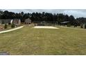 A grassy open space with a volleyball court, trees and homes in the distance at 5320 Tolar Rd, South Fulton, GA 30213