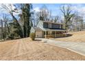 A blue house with a covered porch and a long driveway on a grassy hill at 801 Hemingway Rd, Stone Mountain, GA 30088