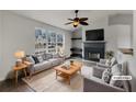 Bright living room with large window, neutral furniture, fireplace, and modern ceiling fan at 10511 Tobano Trl, Jonesboro, GA 30238