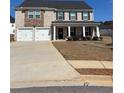 Two-story home featuring a two-car garage, brick facade, and a covered front porch with stately columns at 1367 Midnight Ride Ct, Hampton, GA 30228