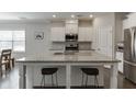 Bright kitchen featuring a large island with granite countertops, seating, and stainless appliances at 1327 Lanier Vista Dr, Buford, GA 30518