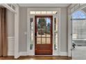 Elegant front door with sidelights and transom window, offering a view of the landscaped front yard at 5810 Ripplestone Nw Ct, Acworth, GA 30101