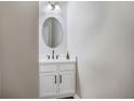 Modern powder room features a sleek vanity, round mirror, and stylish fixtures at 6000 Suttles Drive Sw, Atlanta, GA 30331