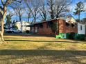 Side view of brick house with green lawn and colorful garden; car parked nearby at 3698 Fairlane Nw Dr, Atlanta, GA 30331