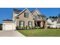 Stately brick residence with a two-car garage, attractive landscaping, and charming stone details on the porch at 2903 Eva Clb, Acworth, GA 30101