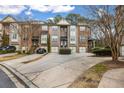 Townhouse complex view showcasing brick facades, driveways, and mature trees at 1992 Cobblestone Ne Cir, Brookhaven, GA 30319