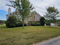 Inviting two-story brick home with landscaped front yard and walkway to the front door at 3885 Laurens Ln, Snellville, GA 30039