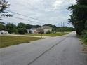 Residential street view with well-maintained lawns and neighboring homes, and a white sedan parked at 3885 Laurens Ln, Snellville, GA 30039