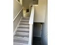 Modern stairway features gray wood stairs, white railing, and neutral-colored walls at 7054 Shenandoah Trl, Austell, GA 30168