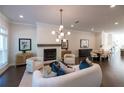 Inviting living room with a white brick fireplace, modern lighting, and open to the dining area at 606 Goldsmith Ct # 114, Johns Creek, GA 30022