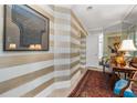 Elegant hallway featuring striped walls, mirrored accents, and a stylish rug at 750 Park Ne Ave # 25W, Atlanta, GA 30326