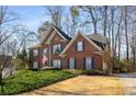 Beautiful brick home with blue shutters, manicured lawn, and mature trees against a clear blue sky at 2212 Austin Lake Se Dr, Smyrna, GA 30082